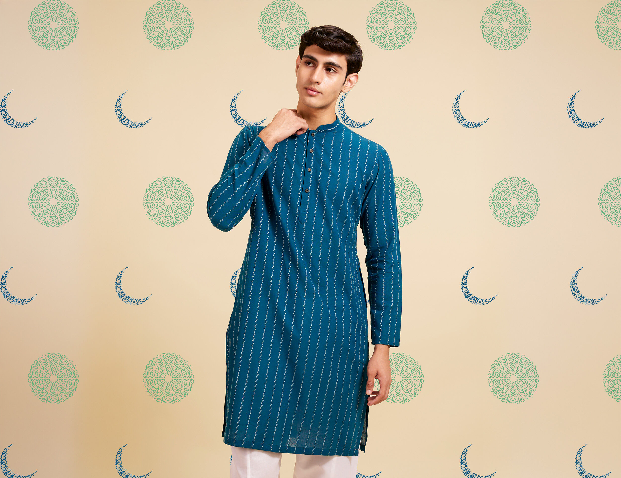 Man dressed in a trendy blue striped kurta with white pants, showcasing a stylish Eid outfit idea